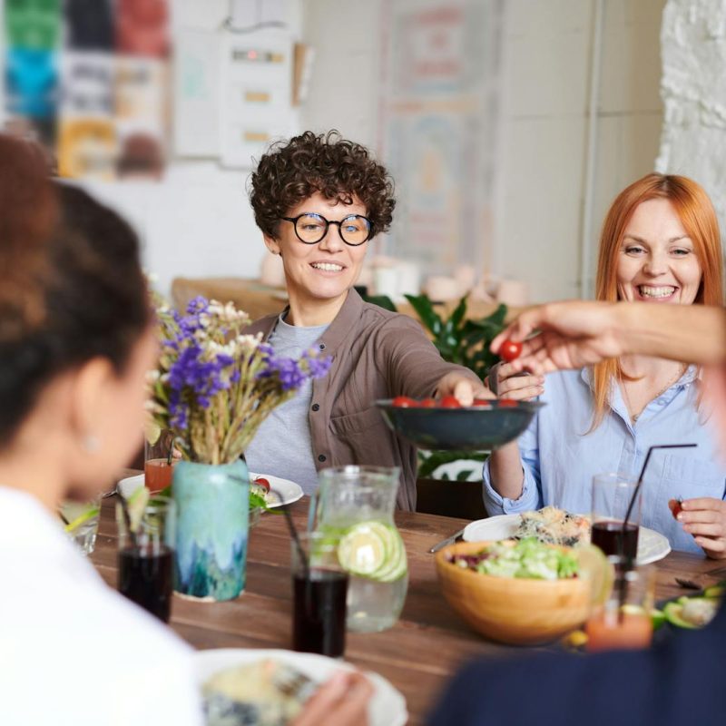 A happy group of friends and family enjoying a meal together indoors. Perfect for themes of togetherness and joy.